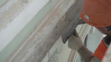 Saint Petersburg, Rusya - 10 Nisan 2018: İnşaat güvenliği üniforması giyen işçi spatula aleti ile duvar sıvaları.