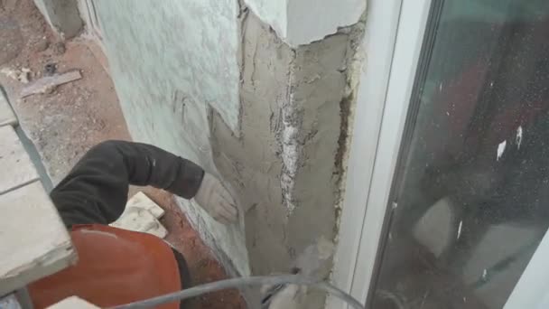 Sankt Petersburg, Ryssland-april 10, 2018: Construction arbetare wiearing väst och hjälm plåster vägg med spackel kniv — Stockvideo