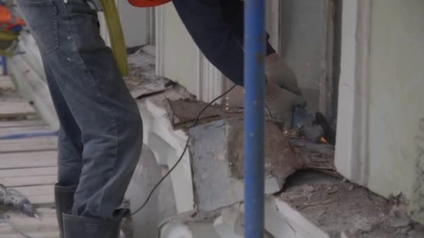 Petrohrad, Rusko-10. duben 2018: stavební pracovník používá řezný stroj k řezání starého prachového kovového dílu zdi — Stock video
