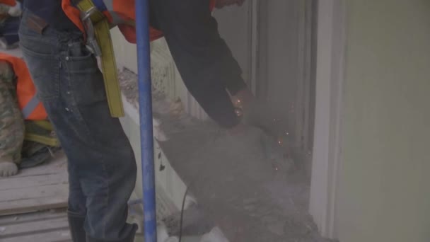 SAINT PETERSBURG, RÚSSIA - 10 de abril de 2018: Trabalhador da construção civil trabalha com máquina de corte de energia para cortar parte da parede — Vídeo de Stock