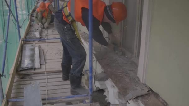 SAINT PETERSBURG, RÚSSIA - 10 de abril de 2018: Construção de trabalhadores do sexo masculino usa máquina de corte para cortar poeira velha parte metálica da parede — Vídeo de Stock