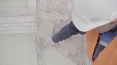 Saint Petersburg, Rusya - 10 Nisan 2018: İnşaat erkek işçisi büyük boya fırçası ile beyaz duvar parçası boyama.