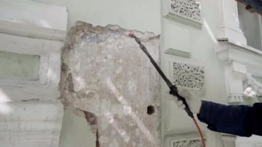 Saint Petersburg, Rusya - 10 Nisan 2018: Duvar parçası, sprey hortumu tutan erkek işçi tarafından boyanmaktadır.