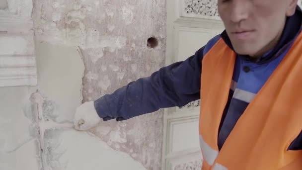 सेंट पीटर्सबर्ग, रूस अप्रैल 10, 2018: निर्माण पुरुष श्रमिक बड़े पेंट ब्रश के साथ सफेद दीवार का टुकड़ा पेंट करता है . — स्टॉक वीडियो