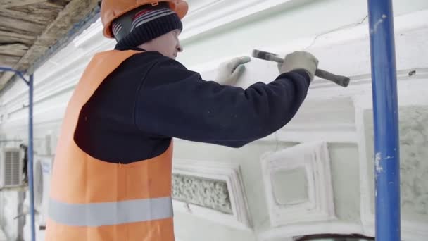 SAINT PETERSBURG, RUSSIA - 10 APRILE 2018: Lavoratore con guanti protettivi usa un piccolo martello per colpire un pezzo di parete della facciata — Video Stock