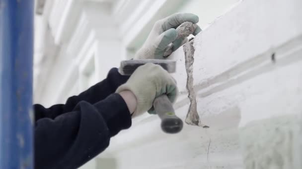 SAINT PETERSBURG, RUSSIE - 10 AVRIL 2018 : Un homme avec des gants de protection utilise un petit marteau pour frapper un mur de façade — Video