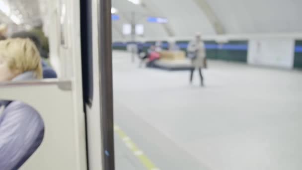 Двері вагона метро закриті і тренуються з людьми, які сидять на переміщеннях сидінь . — стокове відео