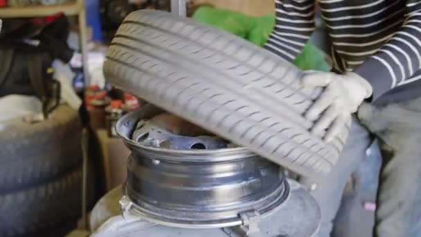 Hombre calificado mecánico de automóviles reemplazar neumático en la rueda en el servicio de reparación de automóviles fuera . — Vídeo de stock