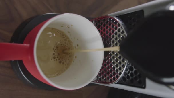 Cappuccino é derramado em copo vermelho colocado na bandeja da máquina de café automática . — Vídeo de Stock