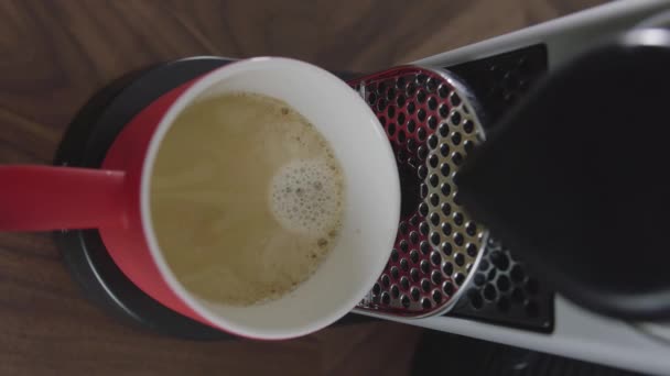 Cappuccino droppar i röd kopp placeras på facket av automatisk kaffebryggare. — Stockvideo
