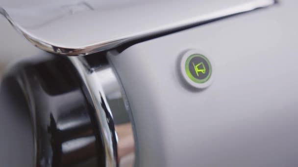 Alguém liga a máquina de café pressionando o botão em forma redonda em seu painel — Vídeo de Stock