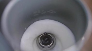 Sütün görünümü, alt kısmında küçük fırçalama ile elektrikli süt dondurmaya dökülür