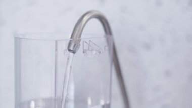 Kahve makinesinin büyük plastik su tankı mutfakta musluk suyu ile doldurulur.