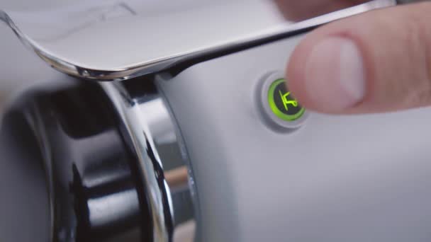 Натискає кнопку круглої форми і вмикає сучасну компактну кавоварку . — стокове відео