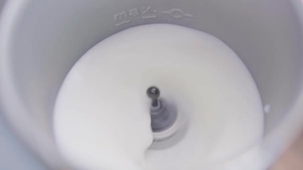 Le lait est secoué dans le mousseur de lait électrique métallique avec un petit wisk sur le fond — Video