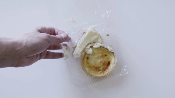 Mans mani gettare contenitore di plastica con torta sul tavolo e coprirlo con piastra — Video Stock