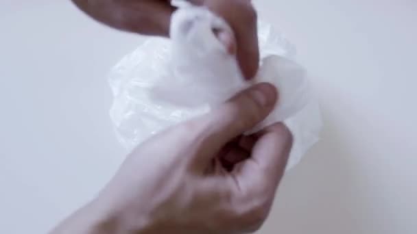 Mão masculina desembrulha saco plástico com bolo em recipiente e mostra dedo médio — Vídeo de Stock