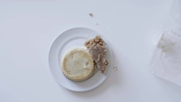 Mans mani prende torta a forma rotonda dal piatto bianco e lo alza verso il basso . — Video Stock