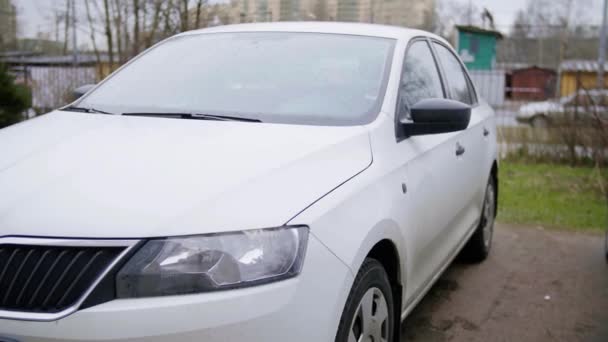 Blanco coche moderno se deja en la calle en gris nublado día de otoño sin gente — Vídeo de stock