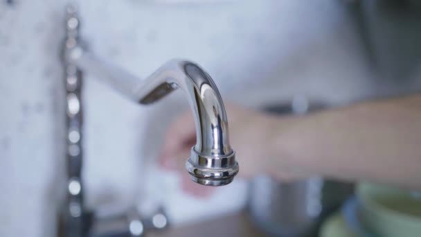 Blick auf Leitungswasser beginnt aus dem Wasserhahn in der Küche zu fließen, wenn jemand es eingeschaltet hat — Stockvideo