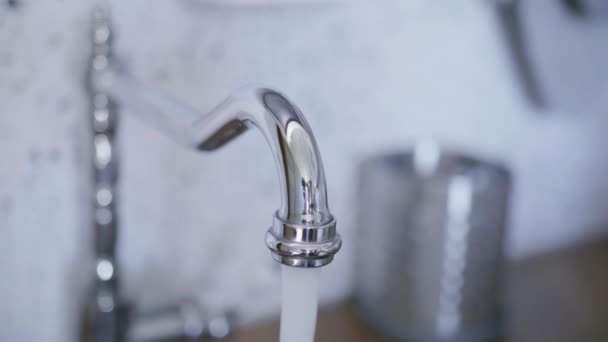 A água limpa começa a fluir da torneira na cozinha quando alguém a ligou — Vídeo de Stock