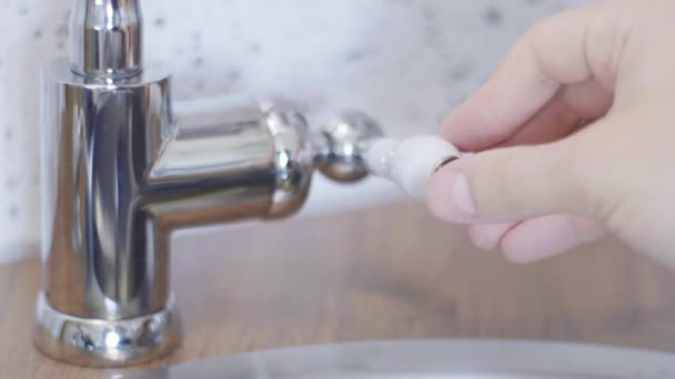 Someones hand is touching tap water faucet to open it so water could flow. — Stock Video