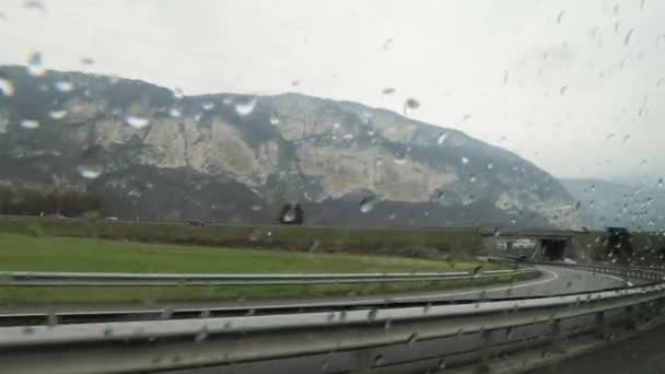 Car is moving on big road in rural area along fields and hills on rainy day. — Stock Video