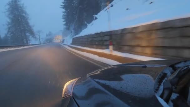 Kar kaplı tepeler boyunca yolda hareket farlar ile siyah modern araba. — Stok video