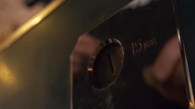 Someones el metal kare çerçeve ile jeton yuvasına küçük sikke takarak