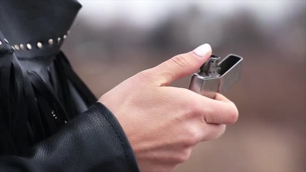 Womans hand repeatedly rolls spark wheel trying to ignite mechanical lighter — Stock Video