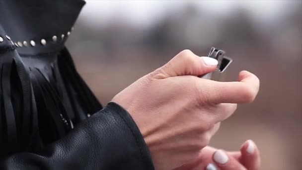 La mano de las hembras está tratando de rodar la rueda de chispa para encender el encendedor mecánico lindo — Vídeo de stock