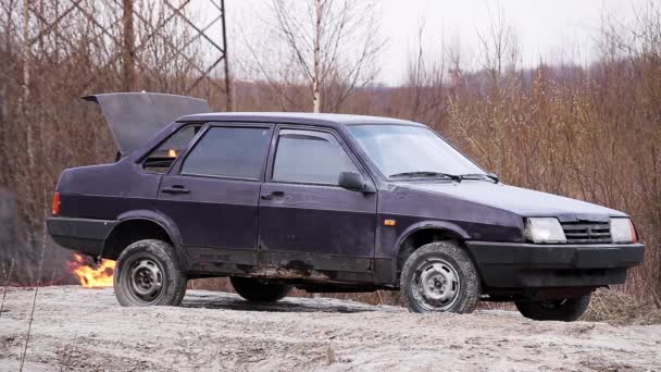 Rusty auto viola è lasciato su strada deserta polvere con tronco in fiamme nelle giornate fredde . — Video Stock