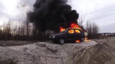 Yangın turuncu alev tamamen ıssız yolda sol kirli eski araba yakar.