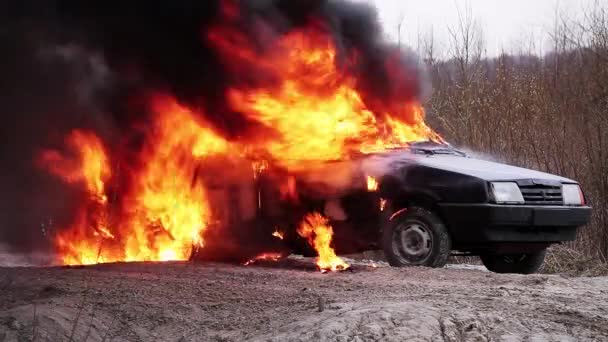 Grote rook vlam van vuur volledig brandt vuile oude auto links op verlaten weg. — Stockvideo