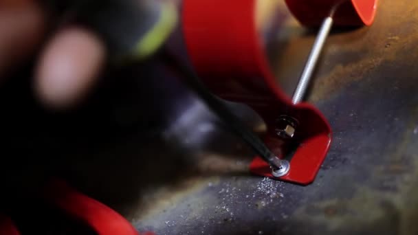 金属表面に新しい赤いステンレスハンドルをねじ込むプロセスのマクロ. — ストック動画