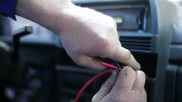 Macro vista de mãos de homem usando instrumento para despir cabos no carro . — Vídeo de Stock