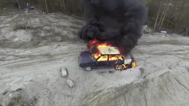 巨大な炎が車と黒い煙が上がる灰色のフィールドの航空写真 — ストック動画