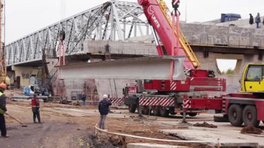 Saint Petersburg, Rusya - 20 Eylül 2018: Köprü inşaat alanı, işçiler yürüyor, beton kiriş iki vinçle kaldırıldı