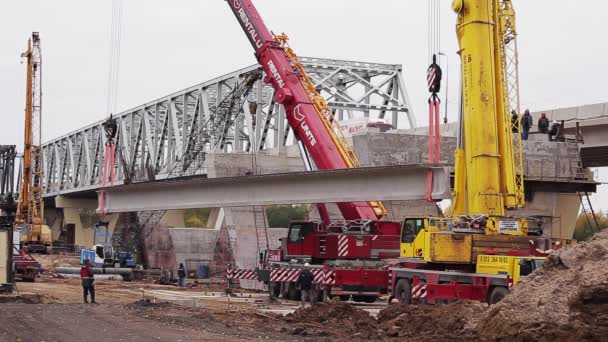 Sankt Petersburg, Ryssland-september 20, 2018: Bridge Construction Zone, arbetare Walk, betong balk lyfts av två kranar — Stockvideo