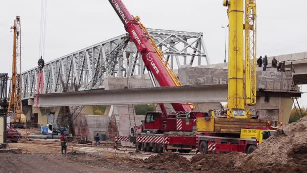 Saint petersburg, russland - 20. september 2018: brückenbaugebiet, wo große betonbalken von zwei kränen angehoben werden — Stockvideo