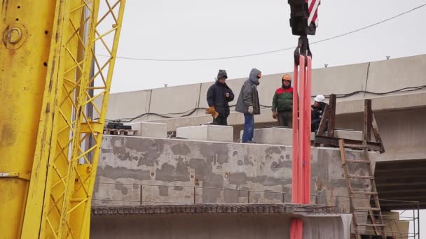 SAINT PETERSBURG, RÚSSIA - SETEMBRO 20, 2018: Zona de construção maciça, trabalhadores caminham, viga de concreto é movida por guindastes — Vídeo de Stock