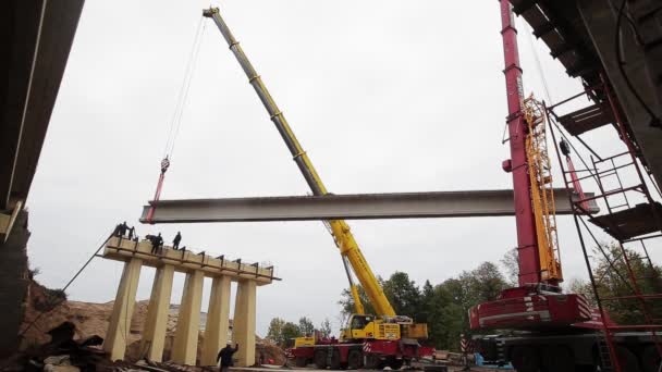 SAINT PETERSBURG, RUSSIA - SEPTEMBER 20, 2018: Zona konstruksi, pekerja yang bekerja seragam, balok beton dipindahkan oleh dua crane — Stok Video