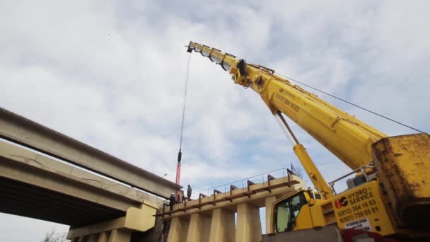 SAINT PETERSBURG, RÚSSIA - SETEMBRO 20, 2018: Enorme novo guindaste amarelo na área de construção maciça com vigas de concreto — Vídeo de Stock