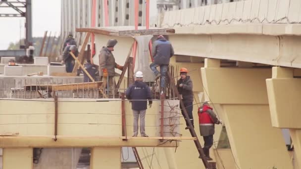 俄罗斯圣彼得堡 - 2018年9月20日:一群工人在巨大的吊混凝土贝姆下参与行动. — 图库视频影像