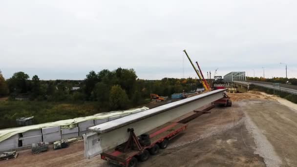 SAINT PETERSBURG, RUSSIA - SEPTEMBER 20, 2018: Top view of bridge construction area with two cranes nearby roadway and field — Stock Video