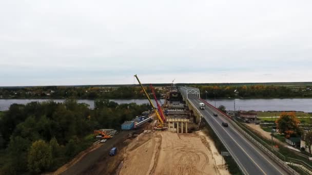 SAINT PETERSBURG, RUSSIA - SEPTEMBER 20, 2018: Aerial view of big construction area with two cranes nearby roadway and field — Stock Video