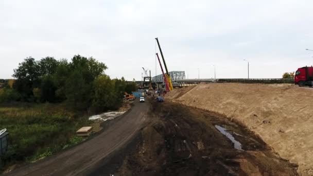 Petrohrad, Rusko-20. září 2018: pohled na masivní staveniště se dvěma jeřáby poblíž silnice a polní — Stock video