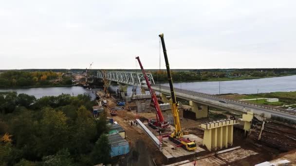 Sankt Petersburg, Ryssland-september 20, 2018: landskap av överbrygga konstruktions område med två kranar i närheten vägbanan och floden — Stockvideo