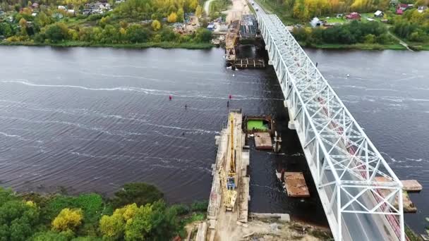 Sankt Petersburg, Rosja-20 września, 2018: aktywna budowa nowego mostu na obszarze z dwoma dźwigów w pobliżu drogi i rzeki — Wideo stockowe