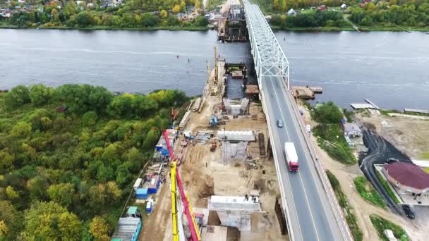 SAN PETERSBURG, RUSIA - 20 DE SEPTIEMBRE DE 2018: Enorme construcción de puentes en la zona con dos grúas cerca de la carretera y el río — Vídeos de Stock